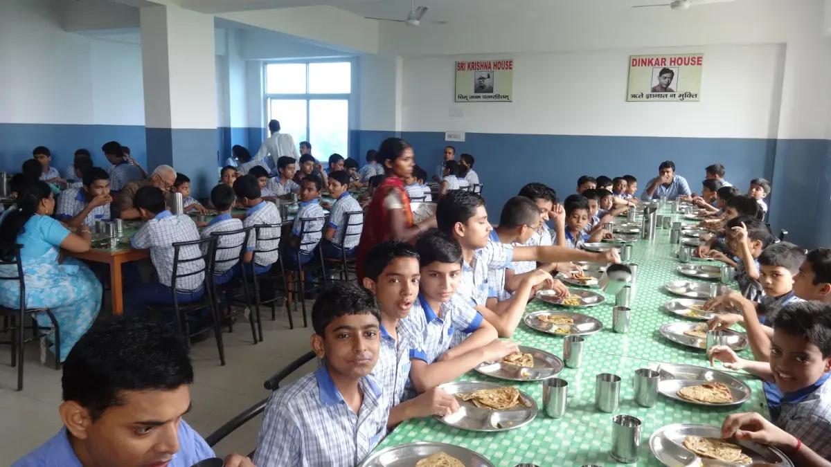 Boarders eating lunch together at long tables in the dining hall