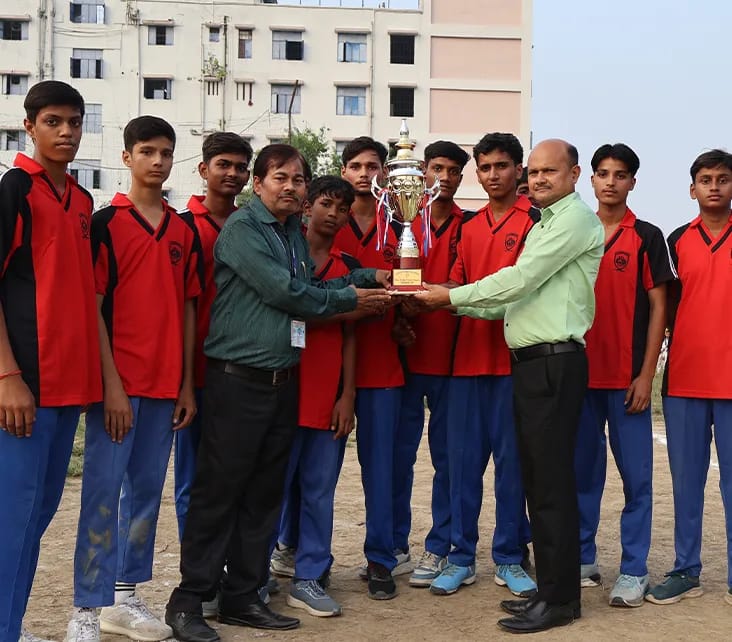 Dinkar House players in red receiving their trophy from teachers