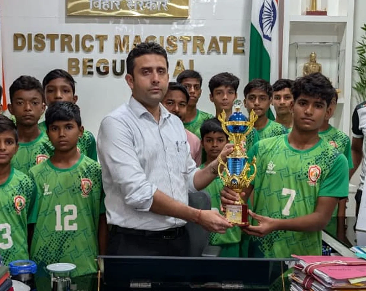 The District Magistrate of Begusarai presenting the trophy to the Doon football team