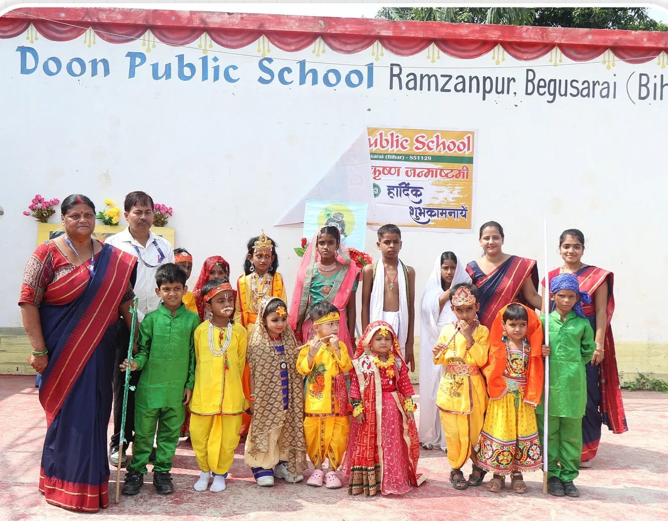 Students dressed as Krishna and Radha with their teachers at the Janmashtami celebration