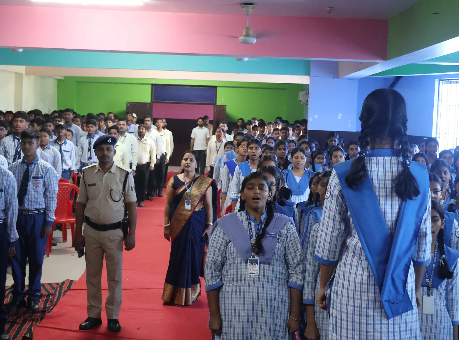 Students and teachers standing together in the hall at the close of the programme