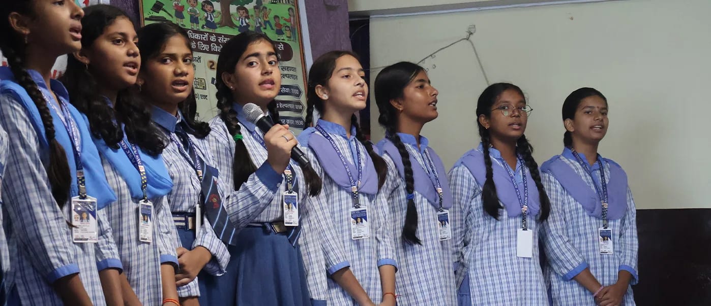Girls singing into microphones on stage