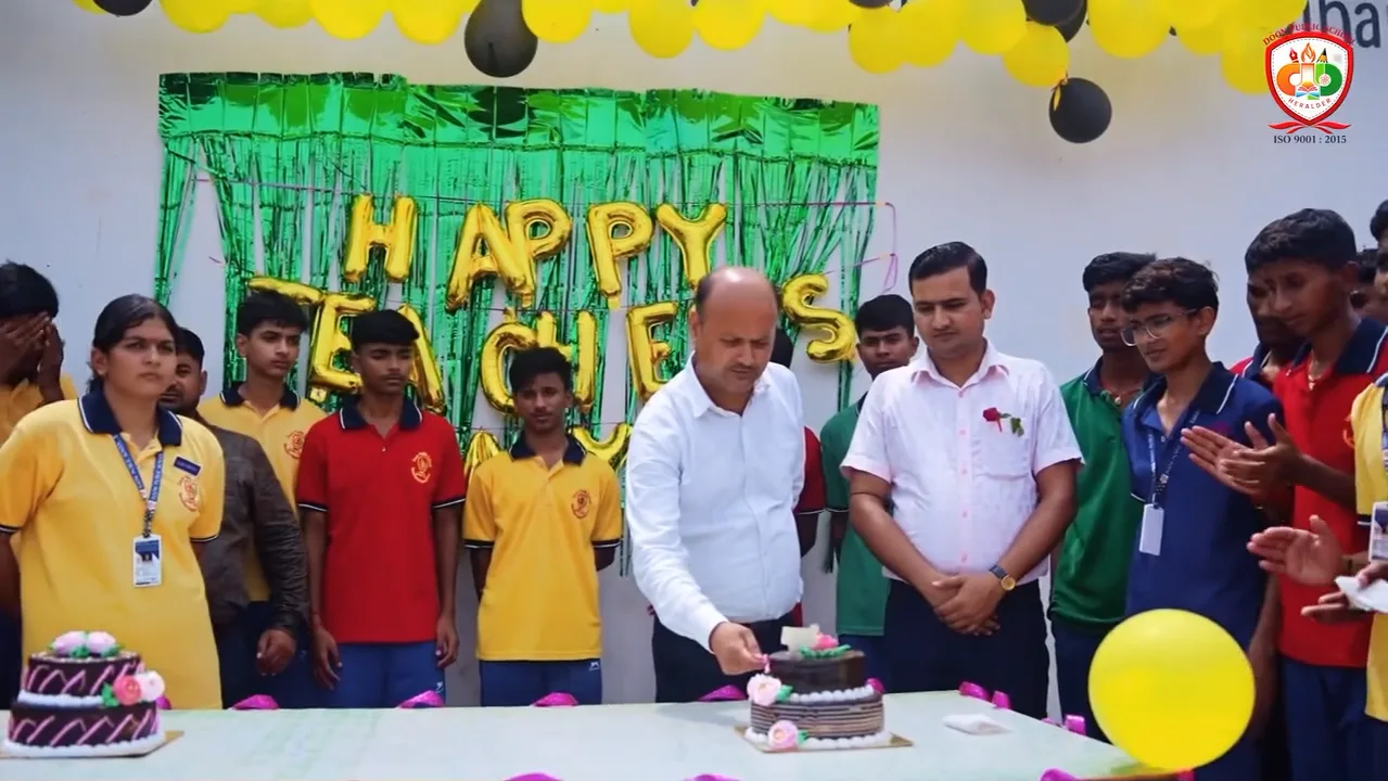 The Principal cutting a cake with students and teachers under a Happy Teachers' Day banner
