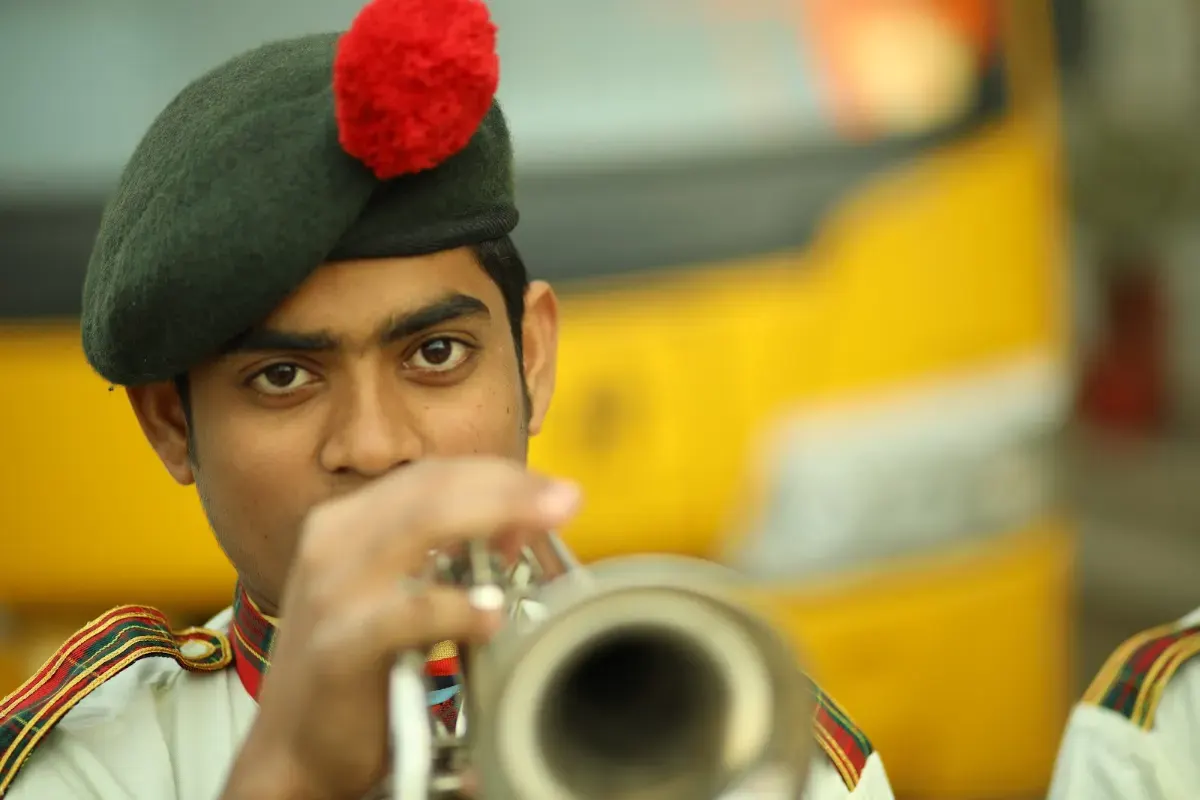 A student of the school band playing the trumpet in uniform