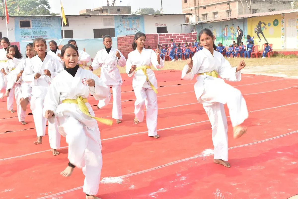 Girls in karate uniforms performing a kata at the athletic meet