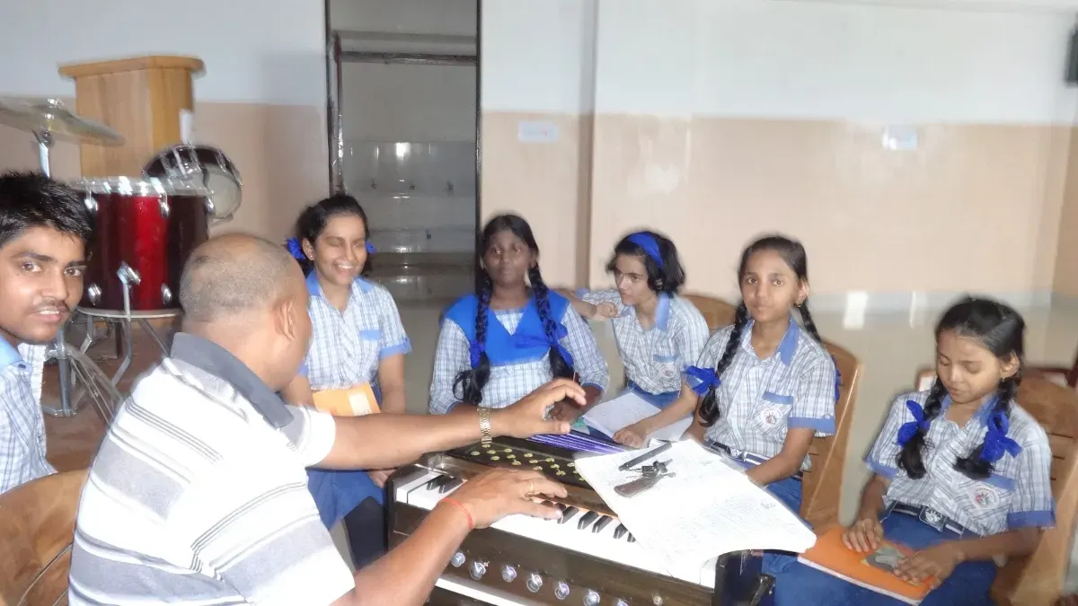 Students learning music around the harmonium with their teacher